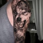 Tattoo realista de lobo y reloj