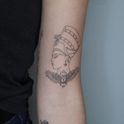 tatuaje retrato Nefertiti en fine line con escarabajo