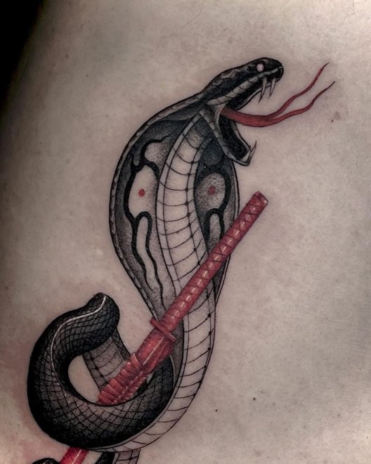 Tatuaje ilustrativo de una cobra en rojo y negro