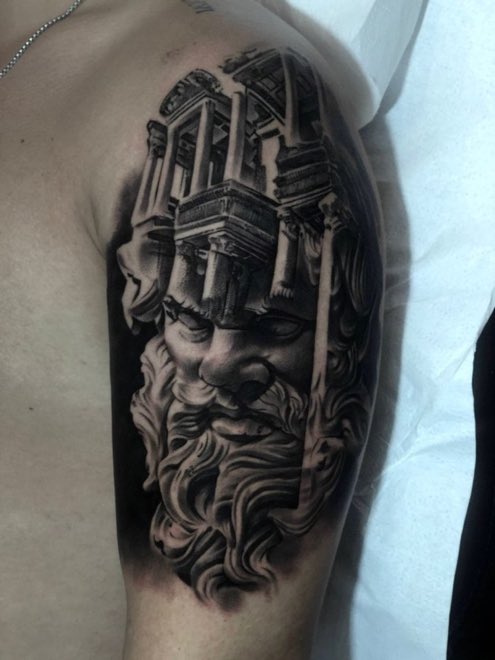 Tatuaje realista en blanco y negro de una escultura en el brazo