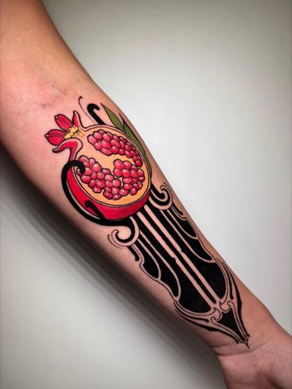 Tatuaje neotradicional a color de una granada